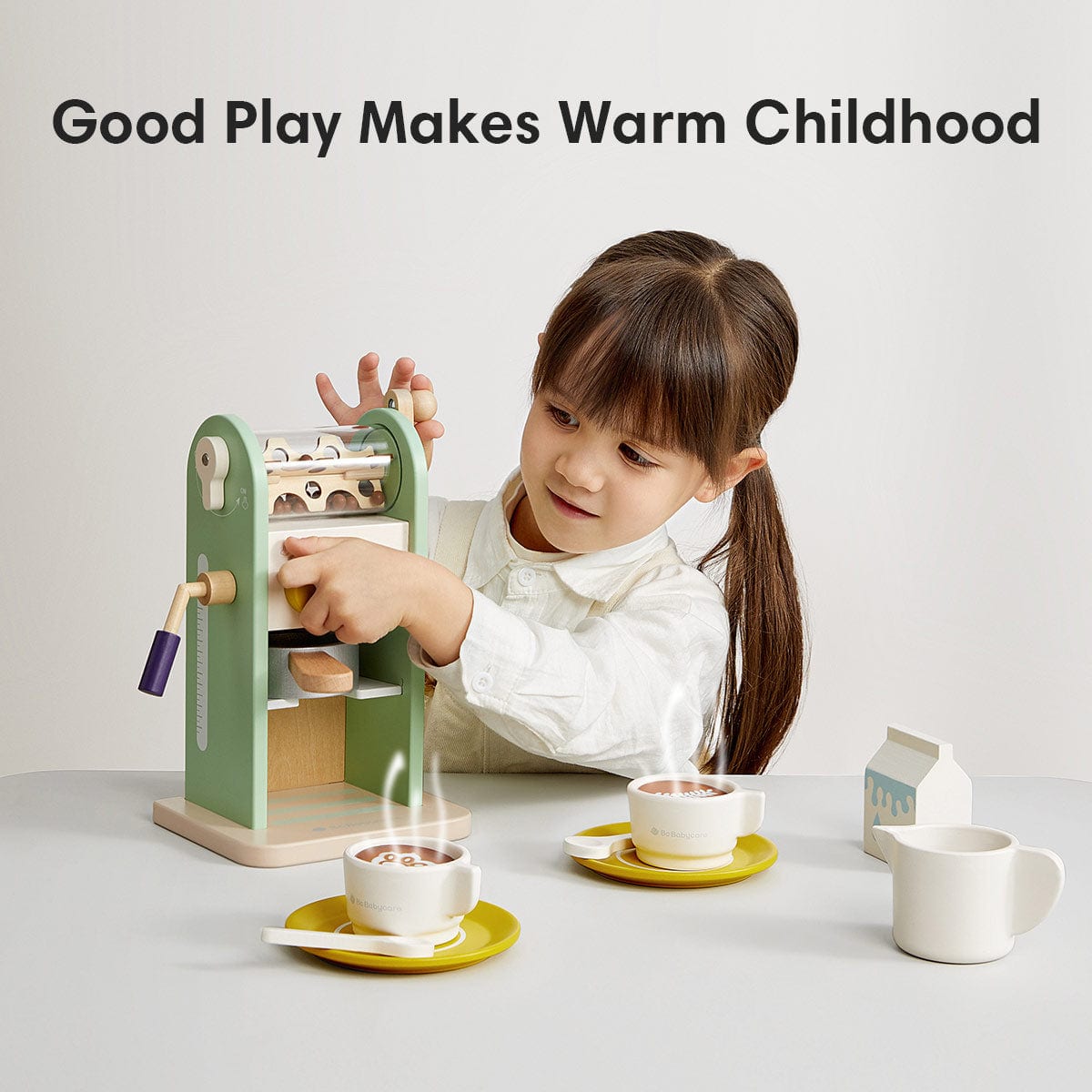an image of a girl is playing the green coffee maker toy.